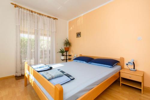 ein Schlafzimmer mit einem großen Bett mit blauen Kissen in der Unterkunft Apartments Zdravka in Krk