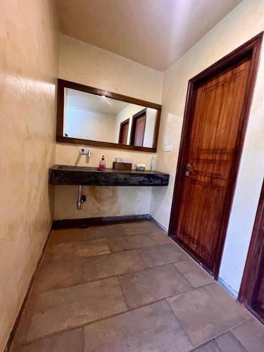 a bathroom with a sink and a mirror at Krsna Farm Villa in Bangalore