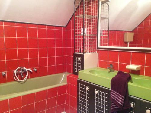 W wyłożonej czerwonymi kafelkami łazience znajduje się zielona umywalka i wanna. w obiekcie Holiday home with private parking Vukovar w mieście Vukovar