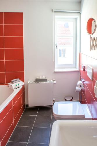 a bathroom with a tub and a toilet and a window at Hotel am Markt in Hungen