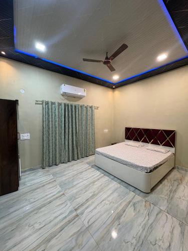 a bedroom with a bed and a ceiling fan at Kiyanshi Farm in Murbād