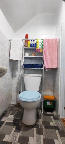 a bathroom with a toilet with a shelf above it at John and Novy's beach bungalows in San Francisco