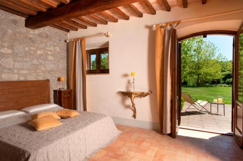een slaapkamer met een bed en een glazen schuifdeur bij Villa Collombroso by PosarelliVillas in Porano