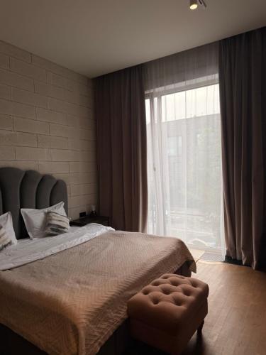 a bedroom with a large bed and a large window at ЖК Esentai city in Almaty
