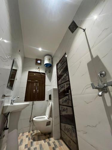 a small bathroom with a toilet and a sink at Hotel Ashok Palace in Agra