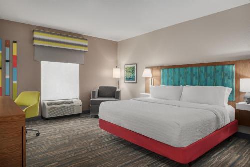 a hotel room with a bed and a chair at Hampton Inn Leesburg Tavares in Leesburg