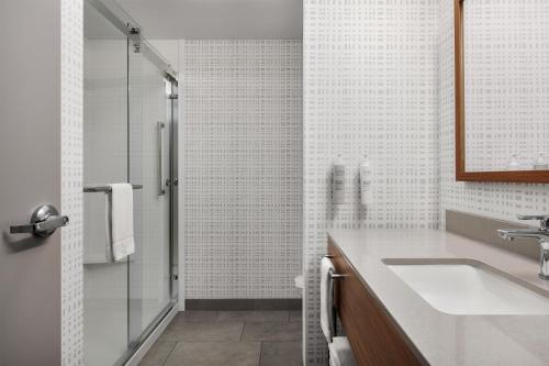 a white bathroom with a sink and a shower at Hampton Inn Leesburg Tavares in Leesburg