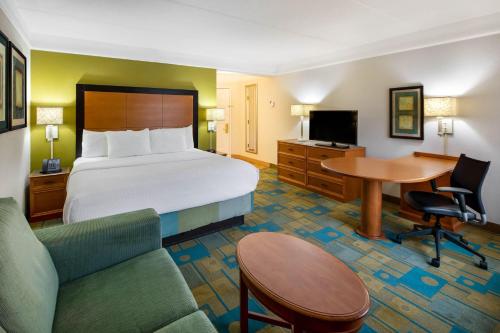 a hotel room with a bed and a desk at La Quinta by Wyndham Haywood Mall-Near Greenville Downtown in Greenville