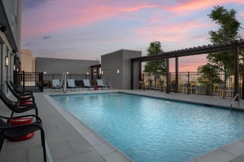 a swimming pool on a building with a sunset at Tru By Hilton Concord Charlotte in Concord