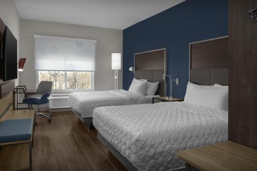 a hotel room with two beds and a window at Tru By Hilton Concord Charlotte in Concord