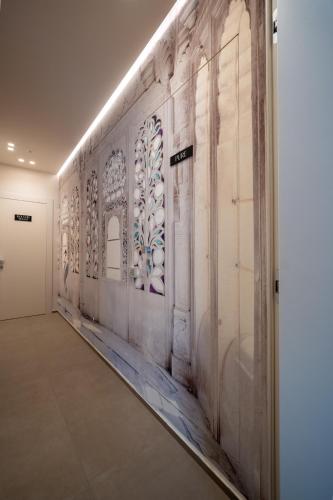 a hallway with a wall with paintings on it at Agorà Luxury Experience in Zafferana Etnea