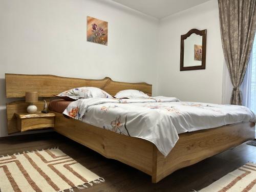 a bedroom with a large bed with a wooden headboard at Casa Stefi si Alexia in Polovragi