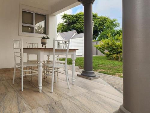 a dining room table and chairs on a patio at Mia Nina in Heatherlands