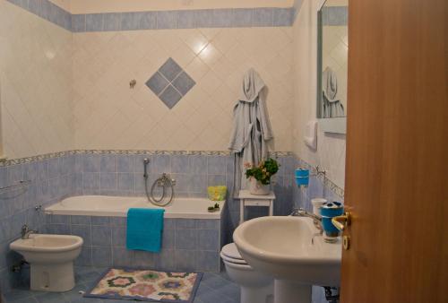 een badkamer met een toilet, een bad en een wastafel bij La piccola casa del cinema in Giffoni Valle Piana