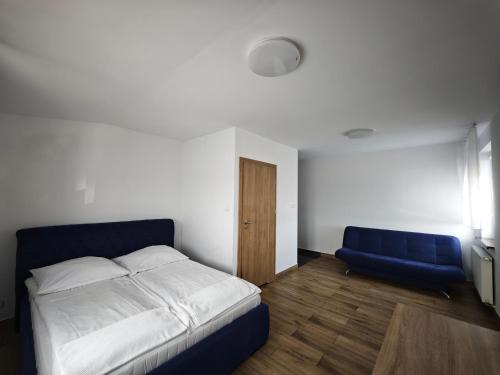 a bedroom with a bed and a blue chair at Alda Gold in Pyrzowice