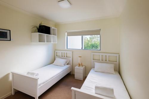 ein Schlafzimmer mit zwei Betten und einem Fenster in der Unterkunft Mill View Link in Albany