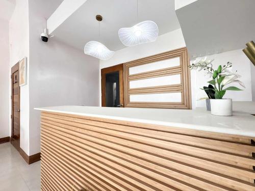 a kitchen with a wooden counter with two lights at Palette Cebu The Almonds Boutique Aparthotel Near University of Cebu in Cebu City