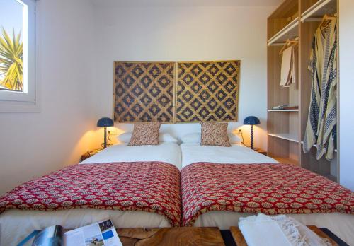 a bedroom with a bed with a red and white blanket at Apartamentos Zahora 37 in Zahora