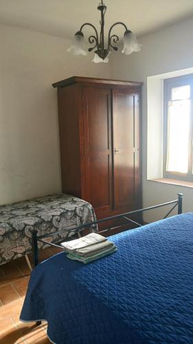 a bedroom with a bed and a dresser with a blue blanket at B&b La Casa Del Sole in Borgaria