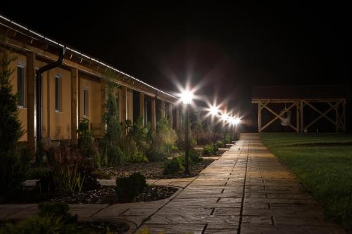 a row of lights on a walkway at night at Relax Apartmanház in Mórahalom
