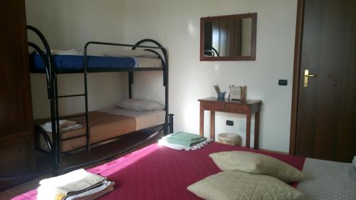 a bedroom with two bunk beds and a mirror at B&b La Casa Del Sole in Borgaria