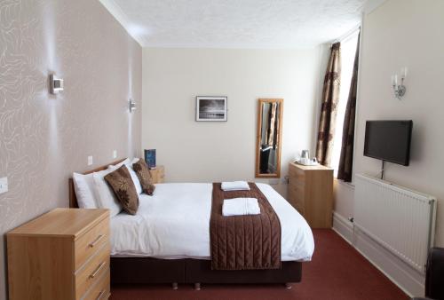 a hotel room with a bed and a tv at Marine Lodge in Great Yarmouth