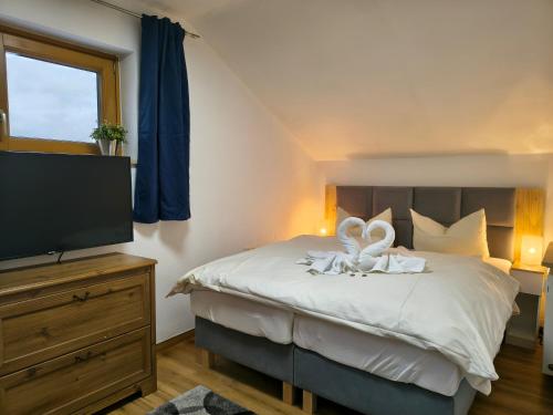 a bedroom with a bed and a flat screen tv at Ferienwohnung Allgäu-Hilaria in Fischen