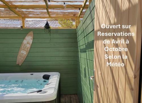 a bath tub with a surfboard on a green wall at Contact Hôtel de Matignon in Matignon