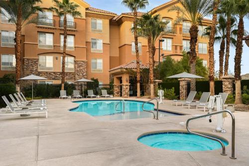 a pool in front of a building with palm trees at Hilton Garden Inn Las Vegas Strip South in Las Vegas