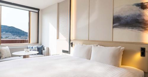 a hotel room with a bed and a window at Heian No Mori Kyoto in Kyoto