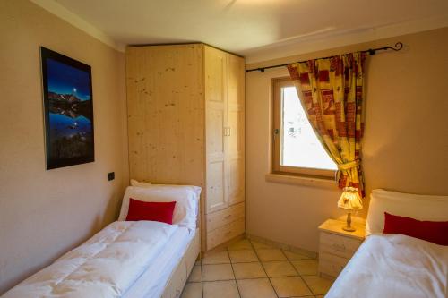 a bedroom with two beds and a window at Chalet La Rugiada in Bormio