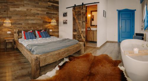 a bedroom with a bed and a bath tub at Heritage Guesthouse in Bartoştana