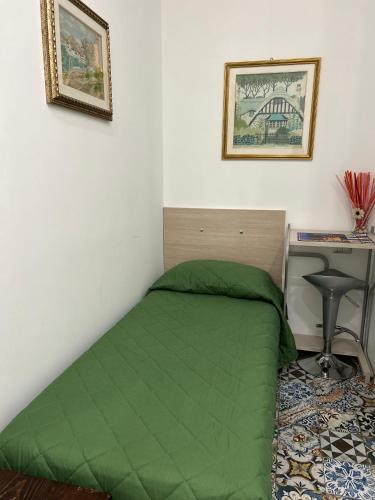 a bedroom with a green bed and a desk at B&B Flora in Piazza Armerina