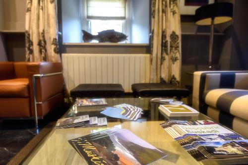 a living room with a table with magazines on it at Hotel Palacio Muñatones in Muskiz