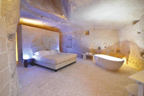 a bedroom with a bed and a bath tub at Le Dimore Dell' Idris in Matera