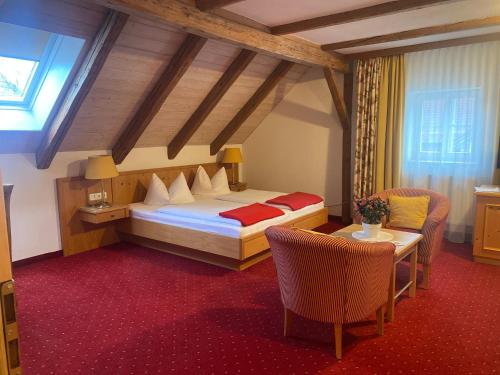 a bedroom with a bed and a table and chairs at Pension zur Post in Waal