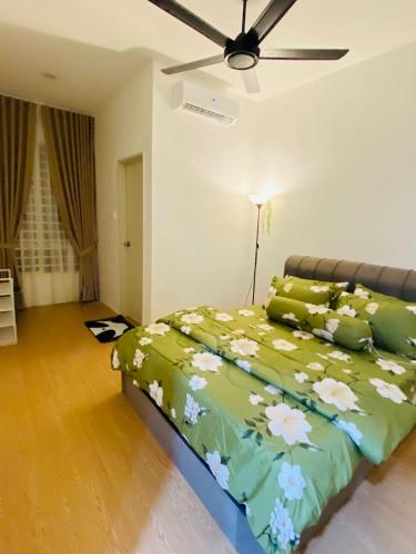a bedroom with a green bed with flowers on it at HomestayBondaFaiiha in Port Dickson