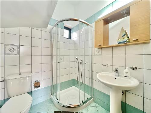 a bathroom with a shower and a sink and a toilet at Elysian Seaside Villa in Almyrida