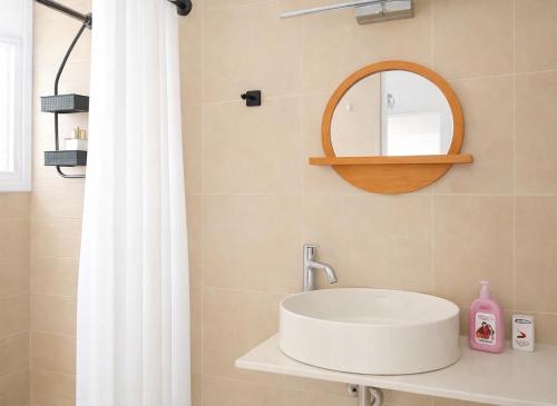 a bathroom with a white sink and a mirror at Navigo house Vrachati in Vrachati