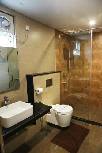 a bathroom with a toilet and a sink and a shower at Sri Suryas Hotel in Colombo