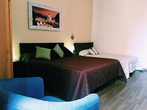 ローマにある4 You City Center Apartamentのベッドルーム1室(ベッド2台、青い椅子付)