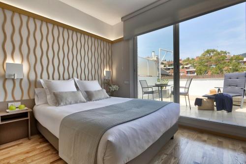 a bedroom with a large bed and a balcony at Bonanova Suite in Barcelona