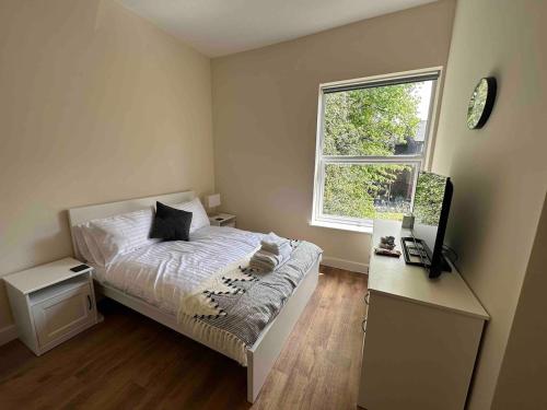 a small bedroom with a bed and a window at Arbourfield Lodge in Derby
