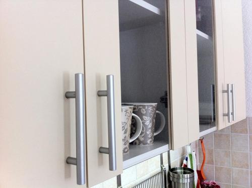 a kitchen cabinet with two cups on a shelf at Apartment Elma in Visoko
