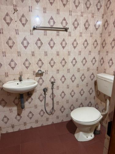 a bathroom with a toilet and a sink at devanjana Guruvayur in Jāmb
