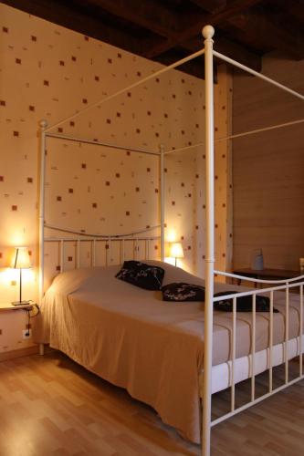 une chambre avec un lit à baldaquin dans une pièce dans l'établissement Le Moulin de Milan, à Cheval-Blanc