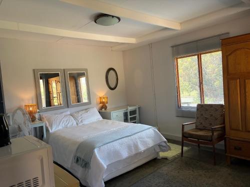 a bedroom with a bed and a desk and a chair at Shabach Farm in Hartebeest Rivier