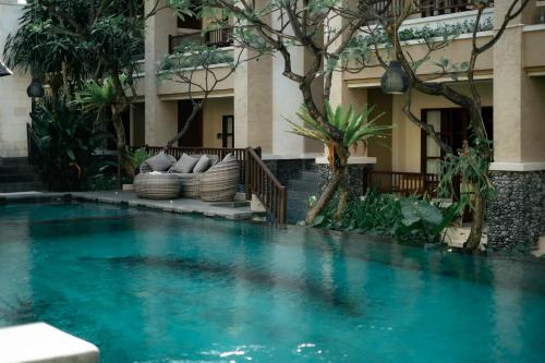 a swimming pool in front of a building at Fourteen Roses Beach Hotel in Legian