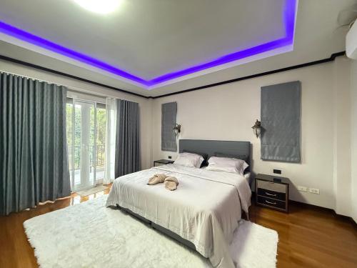 a bedroom with a large bed with a purple lighting at Sufficient House in Nong Prue