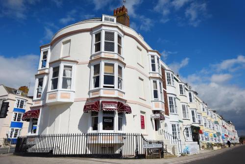 a large white building on the side of a street at The Beach House in Weymouth